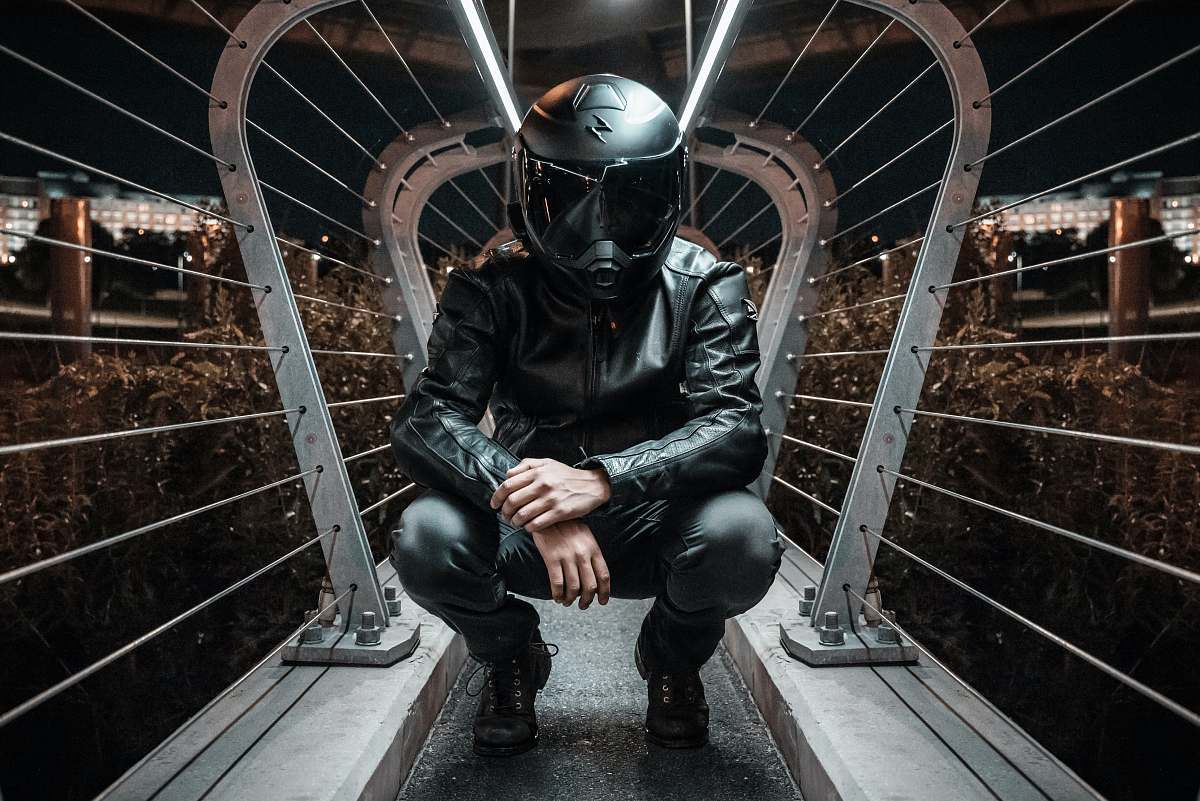 boston man in black full-face motorcycle helmet and jacket boot